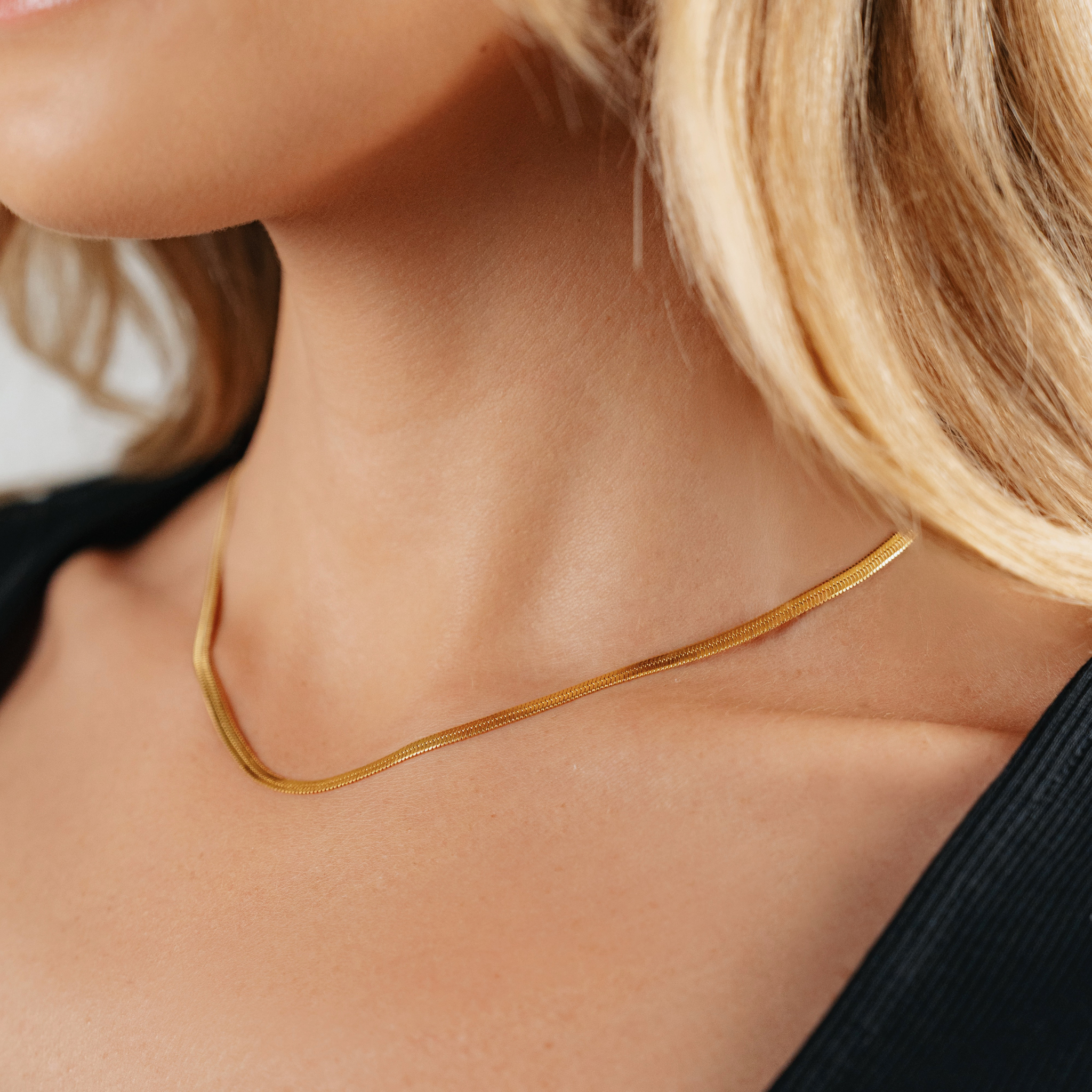 A female wearing SAAR CO's Ale, a polished stainless steel or 18K gold plated Snake Chain. 