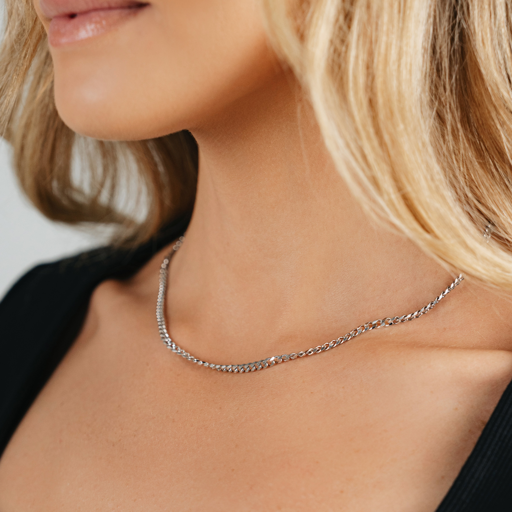 A female wearing SAAR CO's Siobhan, a stainless steel, 3mm Cuban link chain. 